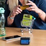 Kobieta trzymająca kartę kredytową w ręku mini wózek zakupowy w tle koncepcja płatności bez gotówki