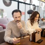 Mężczyzna i kobieta w jasnych swetrach patrząc na próbki drewna