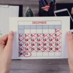 Kobiece ręce trzymając kalendarz z zakreśloną datą nowego roku