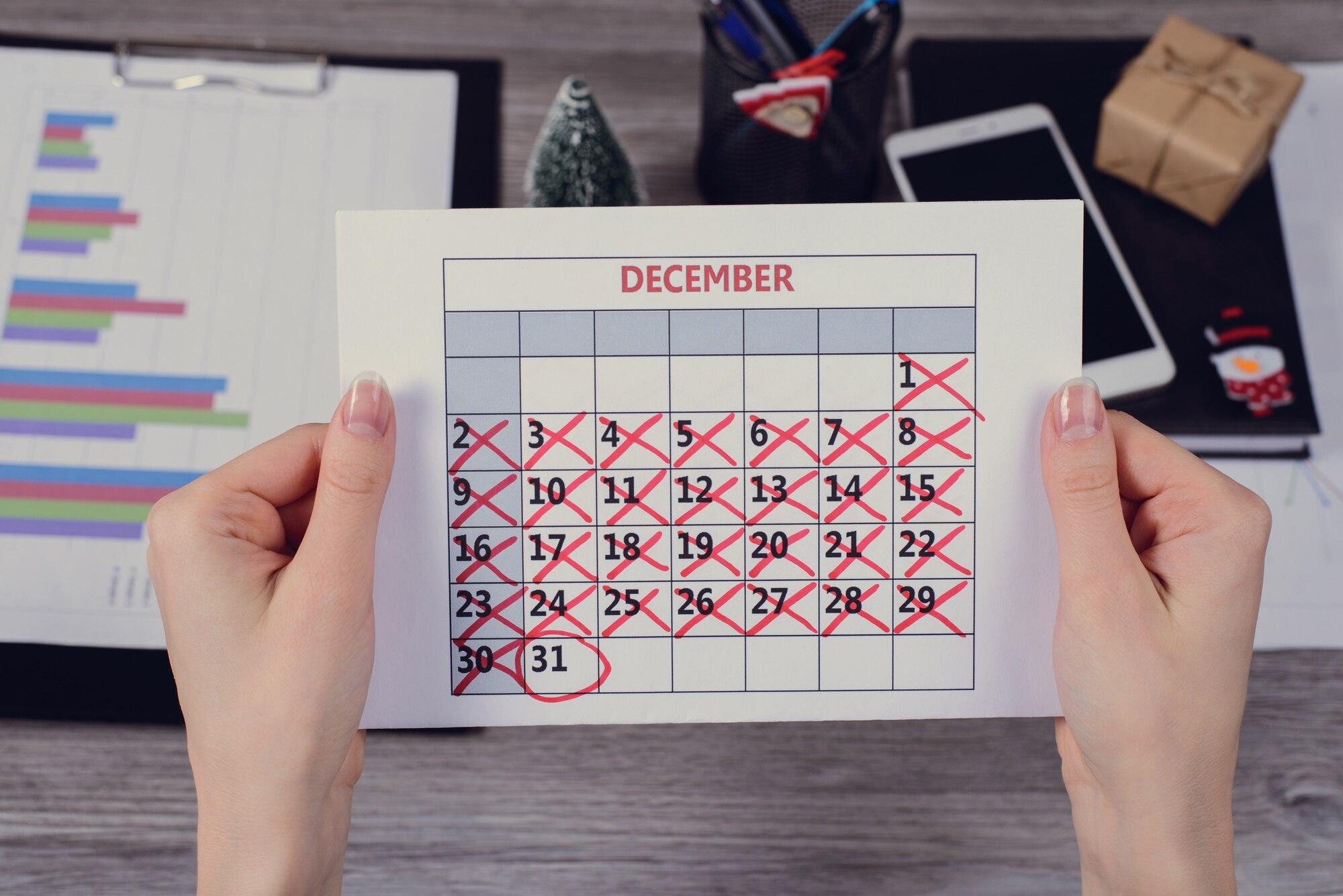 Kobiece ręce trzymając kalendarz z zakreśloną datą nowego roku