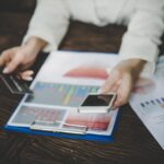 Środkowa sekcja kobiety używającej smartfona przy stole