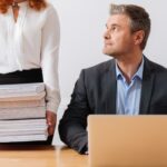 Silna, pracowita ładna pani trzymająca kupę dokumentów biznesmen, który potrzebuje przeglądu do końca dnia roboczego