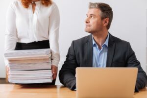 Silna, pracowita ładna pani trzymająca kupę dokumentów biznesmen, który potrzebuje przeglądu do końca dnia roboczego