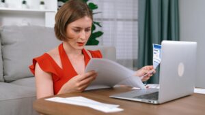 Stresowana młoda kobieta ma problemy finansowe, dług na karcie kredytowej, żeby spłacić Prim.