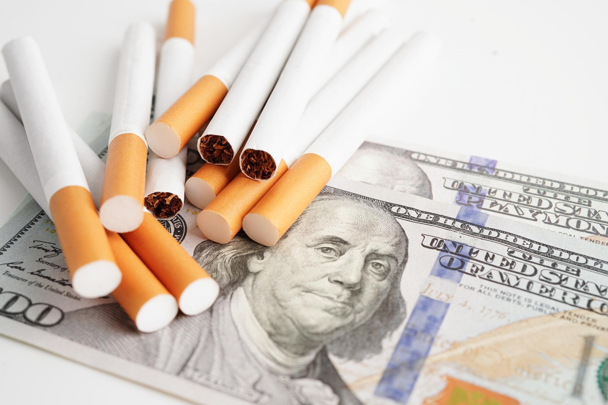 Cigareta na banknotach w dolarach amerykańskich koszt handlu, marketingu i produkcji Bez koncepcji palenia