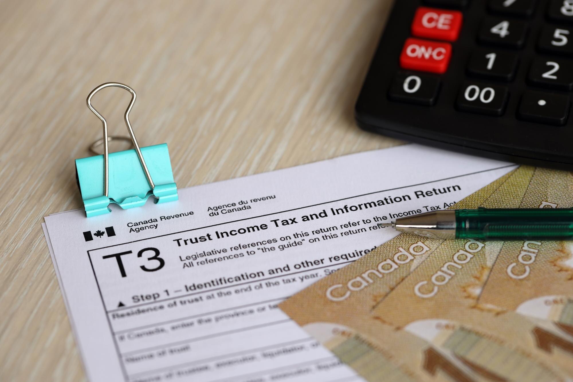 Kanadyjski formularz podatkowy, podatek dochodowy i zwrot informacji leży na stole z kanadyjskimi banknotami.