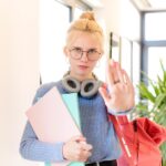 wyglądający poważnie, surowo, niezadowolony i zły pokazując otwartą dłoń, robiąc gest zatrzymania
