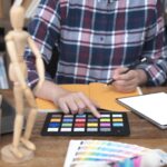 Dwóch artystów pracujących nad kolorowym papierem na biurze