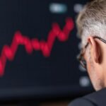 Biznesmen oglądający schemat spadających stóp procentowych wizualizujący kryzys gospodarczy