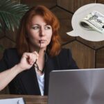 Atrakcyjna kobieta myśli o wynagrodzeniu pieniężnym lub wygranej na loterii