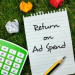 Business conceptText Return on Ad Wydaj pisanie na papierze firmowym z kalkulatora i ołówka na tle trawy
