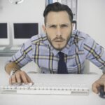 Skoncentrowany przypadkowy biznesmen pracujący przy biurku w swoim biurze