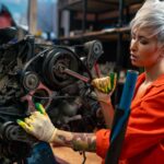 Female mechanic fixing engine in workshop