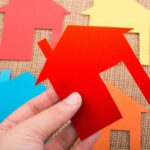 Kształt domku wycięty z kolorowego papieru na tle płótna