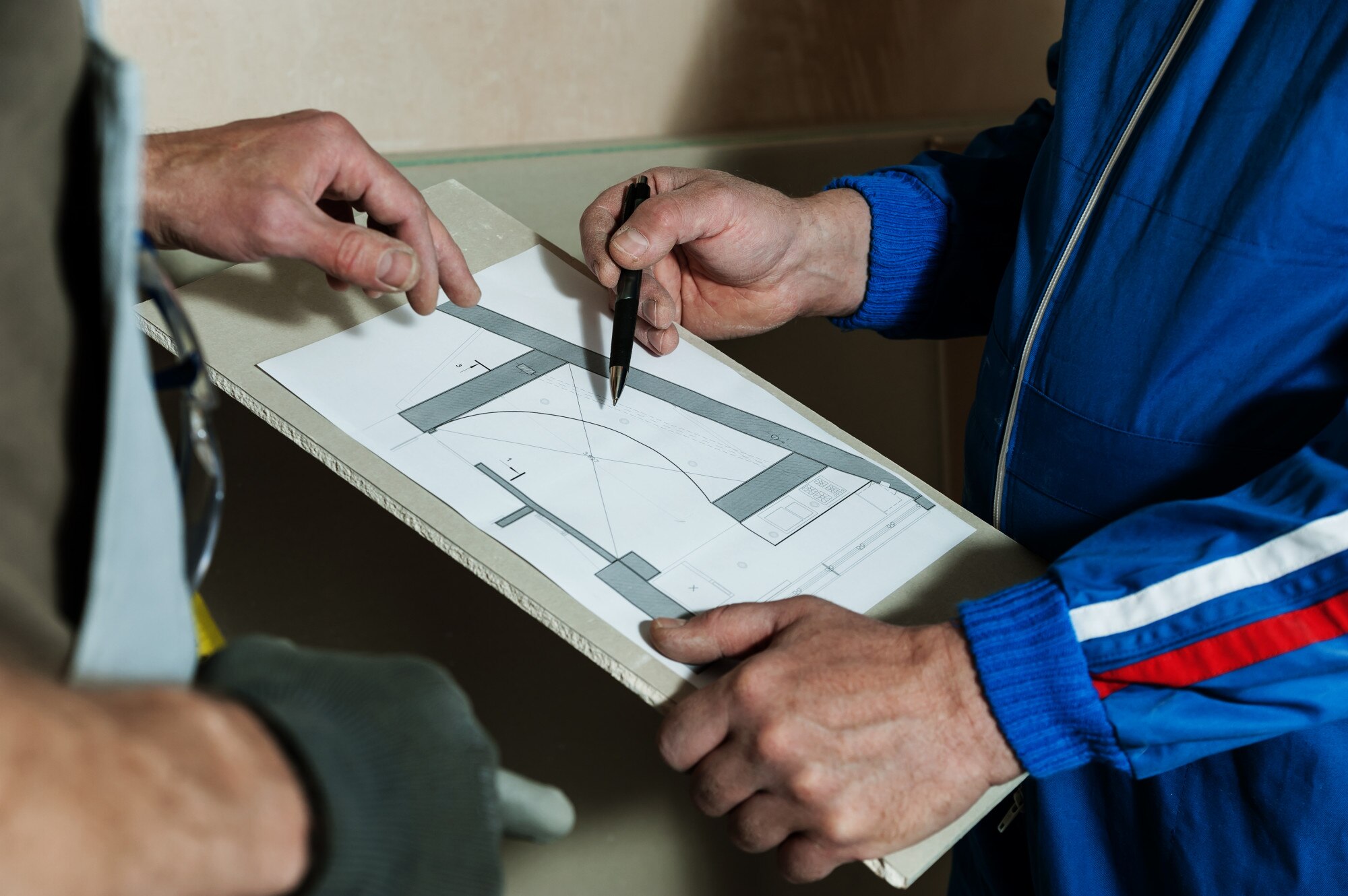 Pracownik i brygadzista omawiają schemat sufitu gipsowo-kartonowego