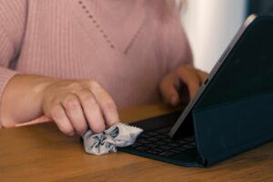 Ręce kobiety oczyszczają ekran tabletu szmatą Technologia higieniczna Closeup Osoba kobieca wyciera urządzenie cyfrowe dezynfektorem na bakterie pyłu brudu Czyszczenie laptopa Dezynfekcja przestrzeni roboczej